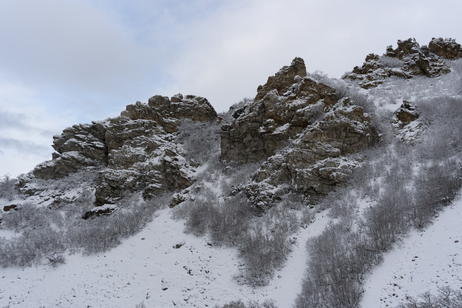 Snowy rocks coming out of the snowy mountainside